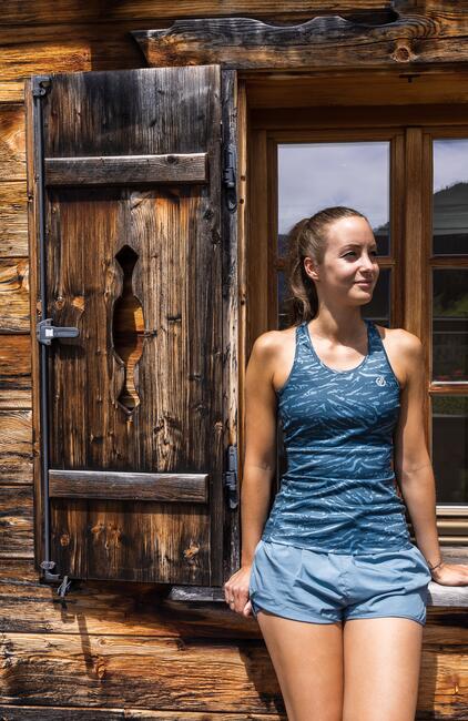 Frau vor einem Holzfenster im Naturhotel Salzburger Land | © www.fabianfranzferdinand.com