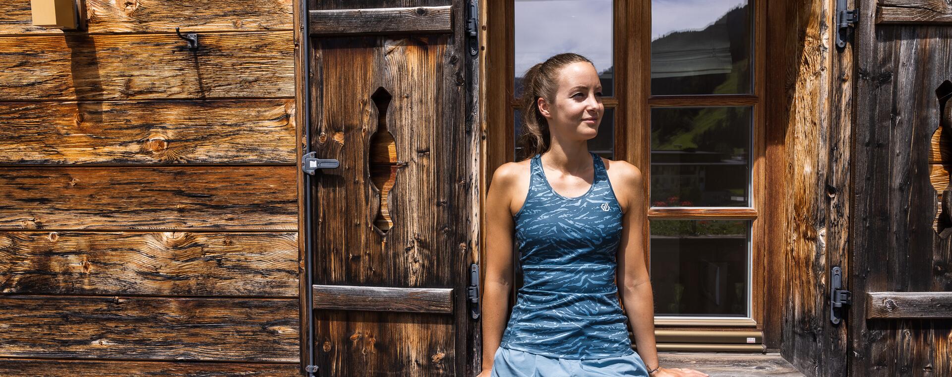 Frau vor einem Holzfenster im Naturhotel Salzburger Land