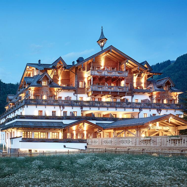 Außenansicht des Boutique Hotel Salzburg bei Abenddämmerung, beleuchtet und umgeben von idyllischer Berglandschaft | © Michael Huber I www.huber-fotografie.at