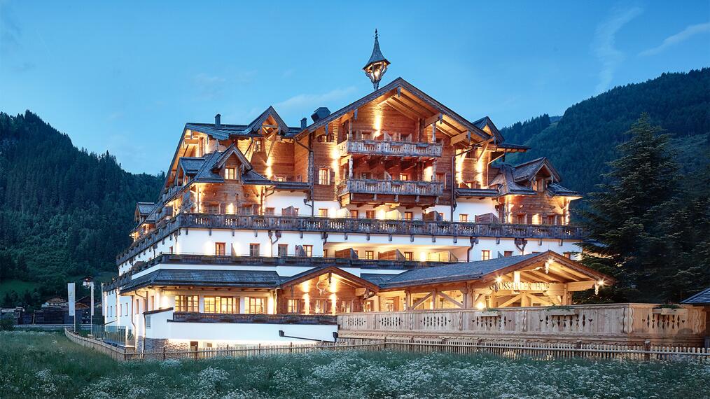 Außenansicht des Boutique Hotel Salzburg bei Abenddämmerung, beleuchtet und umgeben von idyllischer Berglandschaft | © Michael Huber I www.huber-fotografie.at