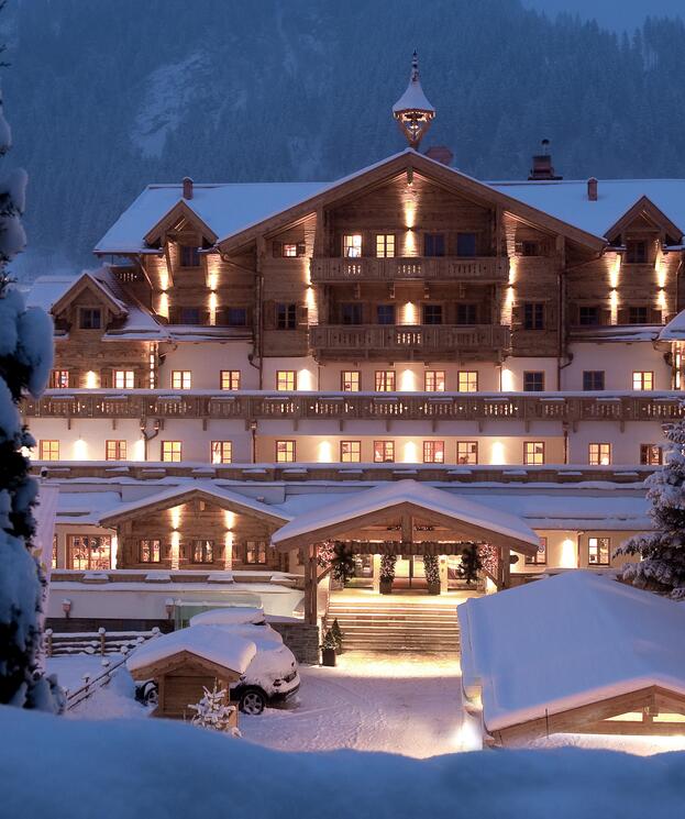 © Michael Huber I www.huber-fotografie.at Winterliche Außenansicht des Boutique Hotel Salzburg bei Nacht, stimmungsvoll beleuchtet und umgeben von verschneiter Berglandschaft | © Michael Huber I www.huber-fotografie.at