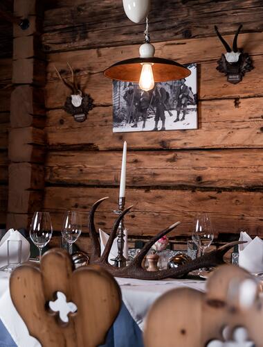 Rustikaler Speiseraum in der Jagastub’n des Boutique Hotel Salzburg mit Holzwänden, Kerzenlicht und traditioneller Dekoration | © www.fabianfranzferdinand.com