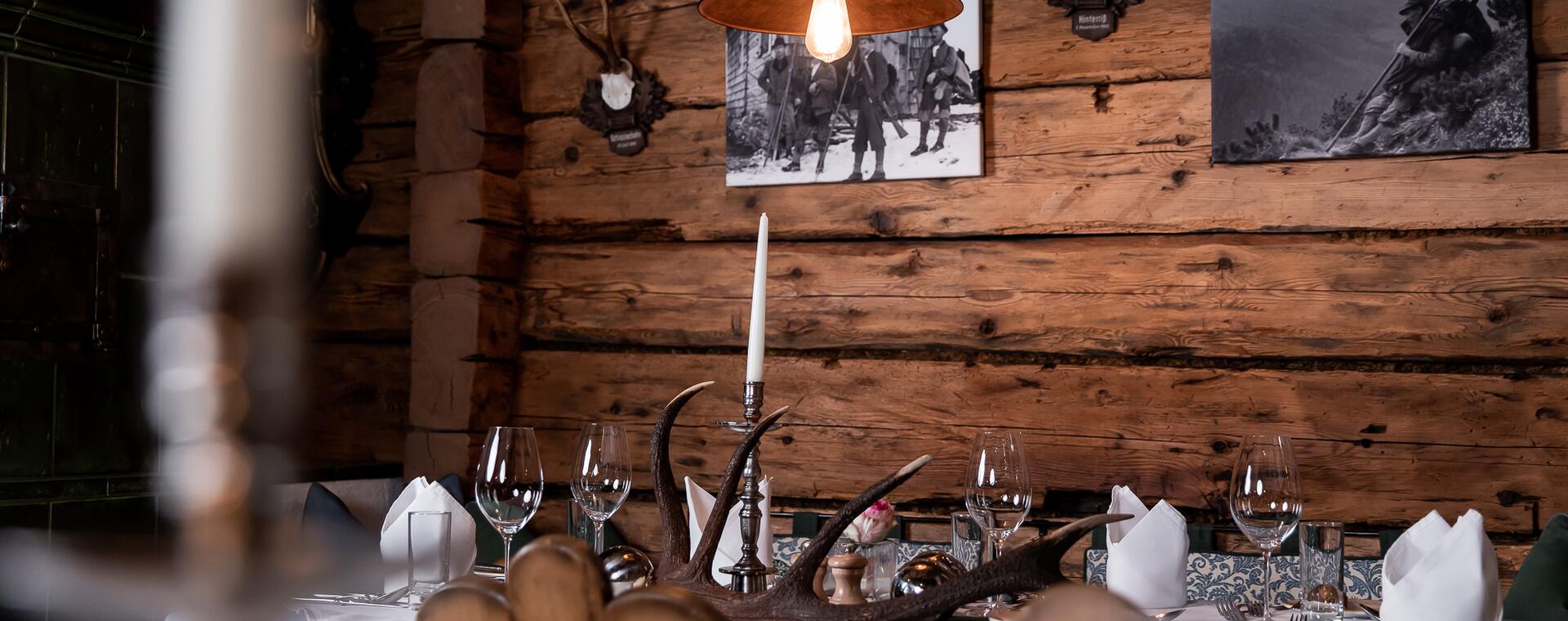 Rustikaler Speiseraum in der Jagastub’n des Boutique Hotel Salzburg mit Holzwänden, Kerzenlicht und traditioneller Dekoration | © www.fabianfranzferdinand.com