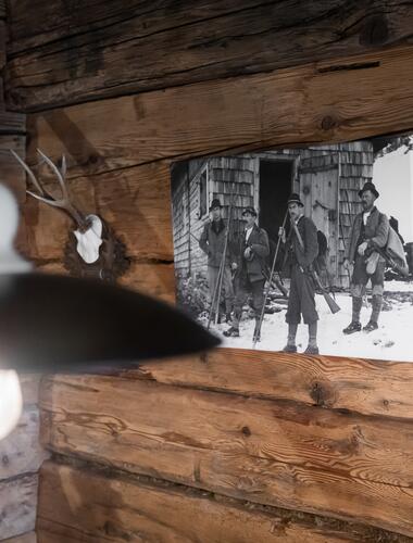 Historisches Foto und Jagdtrophäe an rustikaler Holzwand im Boutique Hotel Salzburg, inspiriert von alpiner Tradition | © www.fabianfranzferdinand.com
