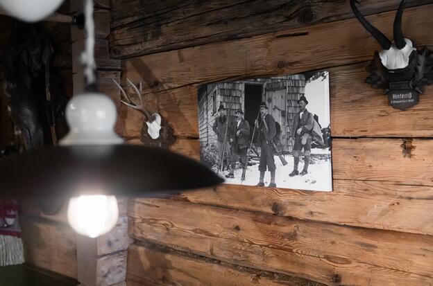 Historisches Foto und Jagdtrophäe an rustikaler Holzwand im Boutique Hotel Salzburg, inspiriert von alpiner Tradition | © www.fabianfranzferdinand.com