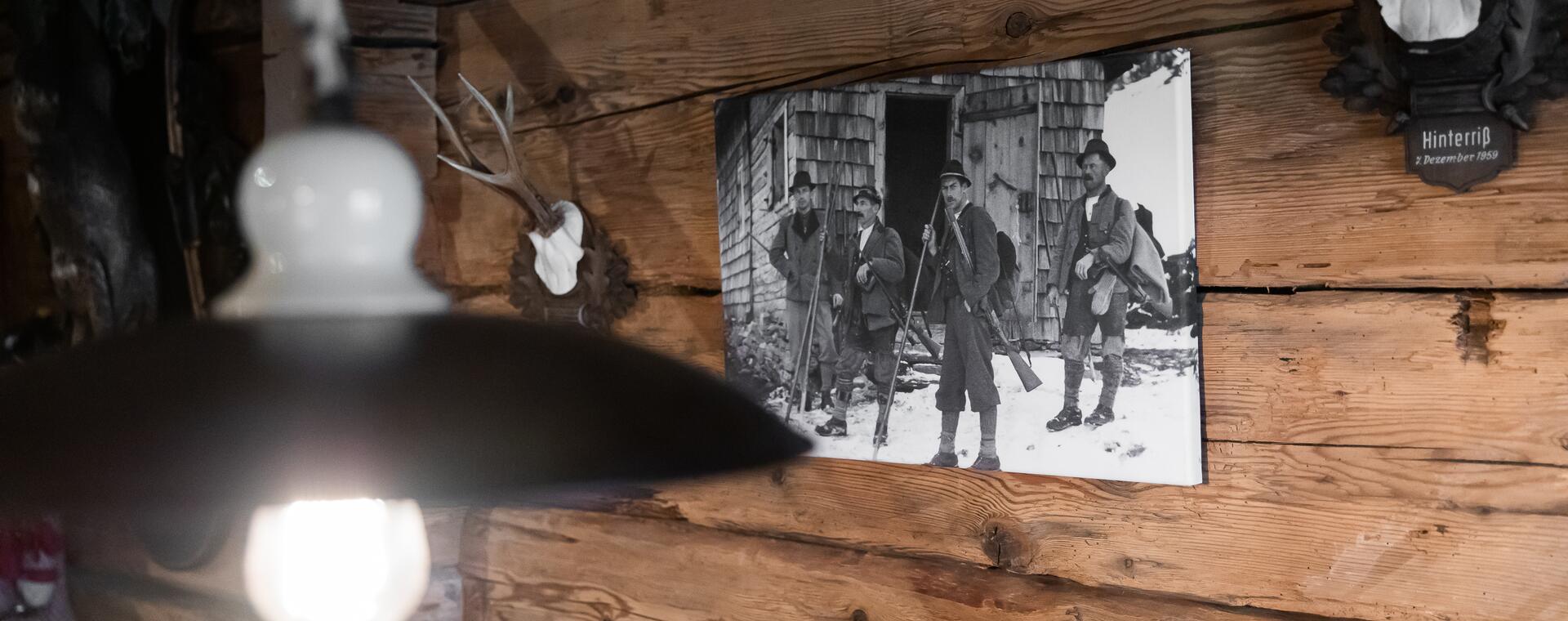 Historisches Foto und Jagdtrophäe an rustikaler Holzwand im Boutique Hotel Salzburg, inspiriert von alpiner Tradition | © www.fabianfranzferdinand.com