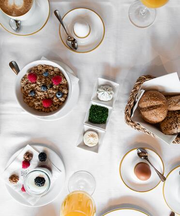 Reichhaltiges Frühstück im Boutique Hotel Salzburg mit Müsli, frischen Beeren, Gebäck, Joghurt, Ei und Säften