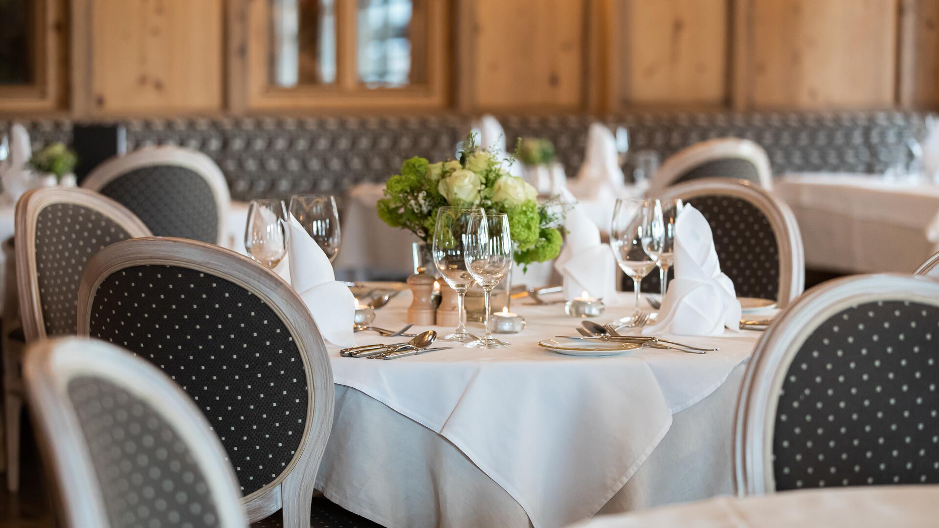 Eleganter Speisesaal im Boutique Hotel Salzburg mit festlich gedeckten Tischen, stilvollen Polsterstühlen und liebevollen Blumendekorationen