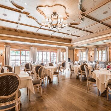 Gemütliches Restaurant im charmanten Hotel in Österreich mit eleganten Tischen und Holzdekor.