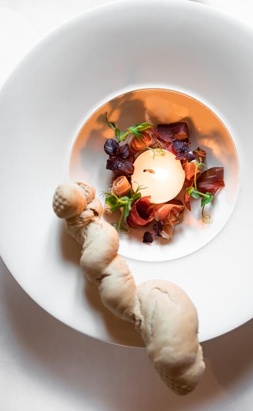 Kreative Gourmet-Vorspeise im Boutique Hotel Salzburg mit kunstvoll angerichteten Zutaten und hausgemachtem Brot