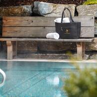 Entspannender Poolbereich im Boutique Hotel Salzburg mit Holzbank, Handtüchern und eleganter Tasche für einen erholsamen Aufenthalt