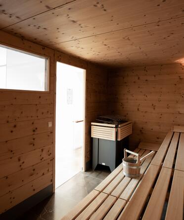 Eine Sauna mit Holzbänken und einem Fenster im Day Spa Salzburger Land