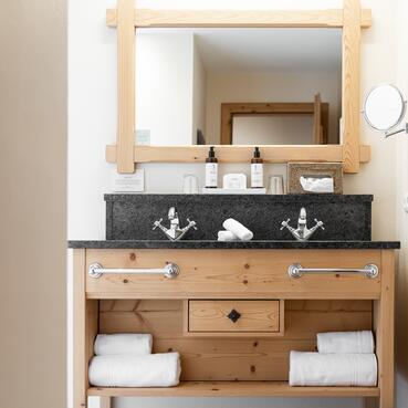 Modernes Badezimmer mit rustikalem Holzdesign – stilvoll Übernachten im Salzburger Land | © SPORTALPEN