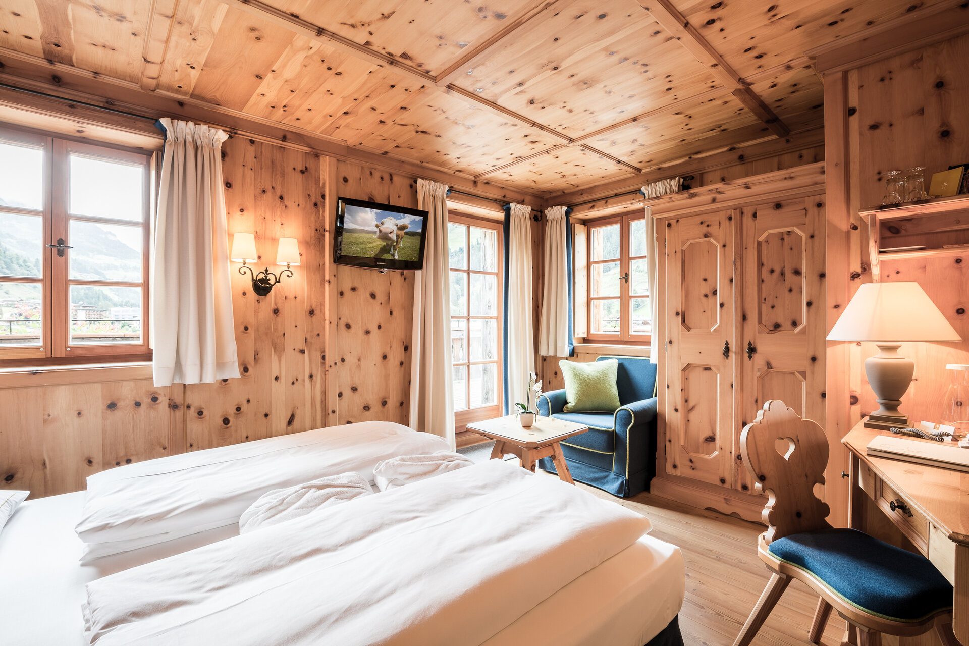 Gemütliches Zimmer im Boutique Hotel Salzburg mit Holzwänden, traditionellen Möbeln, Balkonblick und einladendem Ambiente