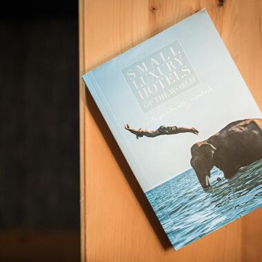 Buch über kleine Luxus-Hotels mit einem Schwimmer und einem Elefanten im Wasser.
