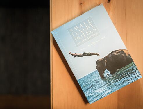 Buch über kleine Luxus-Hotels mit einem Schwimmer und einem Elefanten im Wasser.
