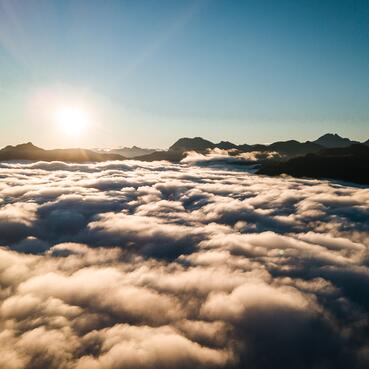 Die Sonne scheint über den Wolken am Himmel über der Berghütte im Salzburger Land.