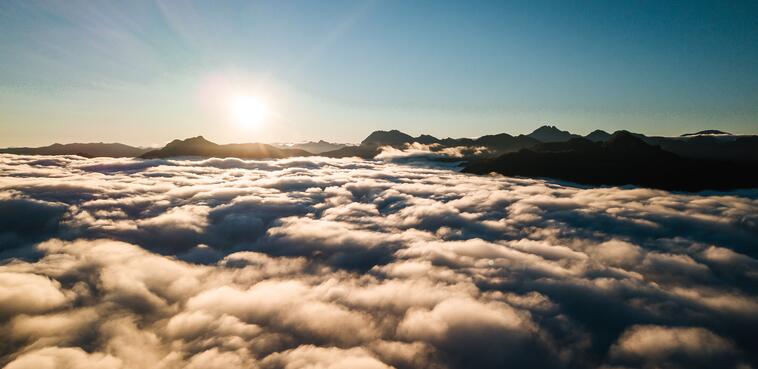 Die Sonne scheint über den Wolken am Himmel über der Berghütte im Salzburger Land.