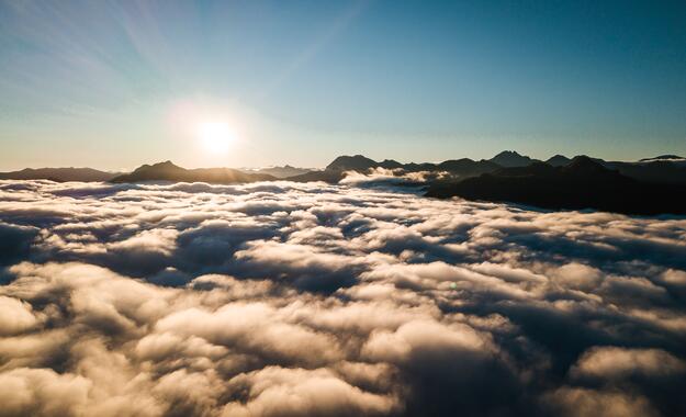Die Sonne scheint über den Wolken am Himmel über der Berghütte im Salzburger Land.