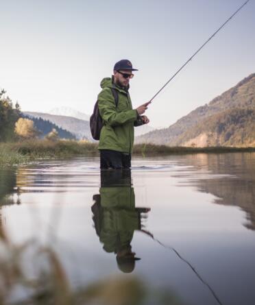 Angler im Wasser bei Sonnenaufgang, im Aktivhotel Salzburger Land. | © Michael Groessinger