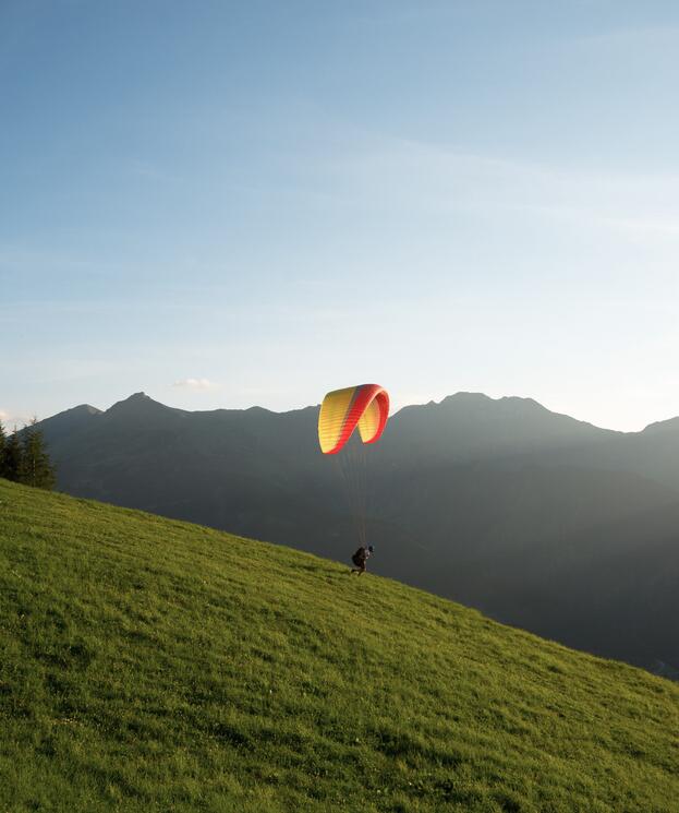 Paragleiter startet vom Sporthotel Salzburger Land, umgeben von beeindruckendem Bergpanorama | © Michael Gruber