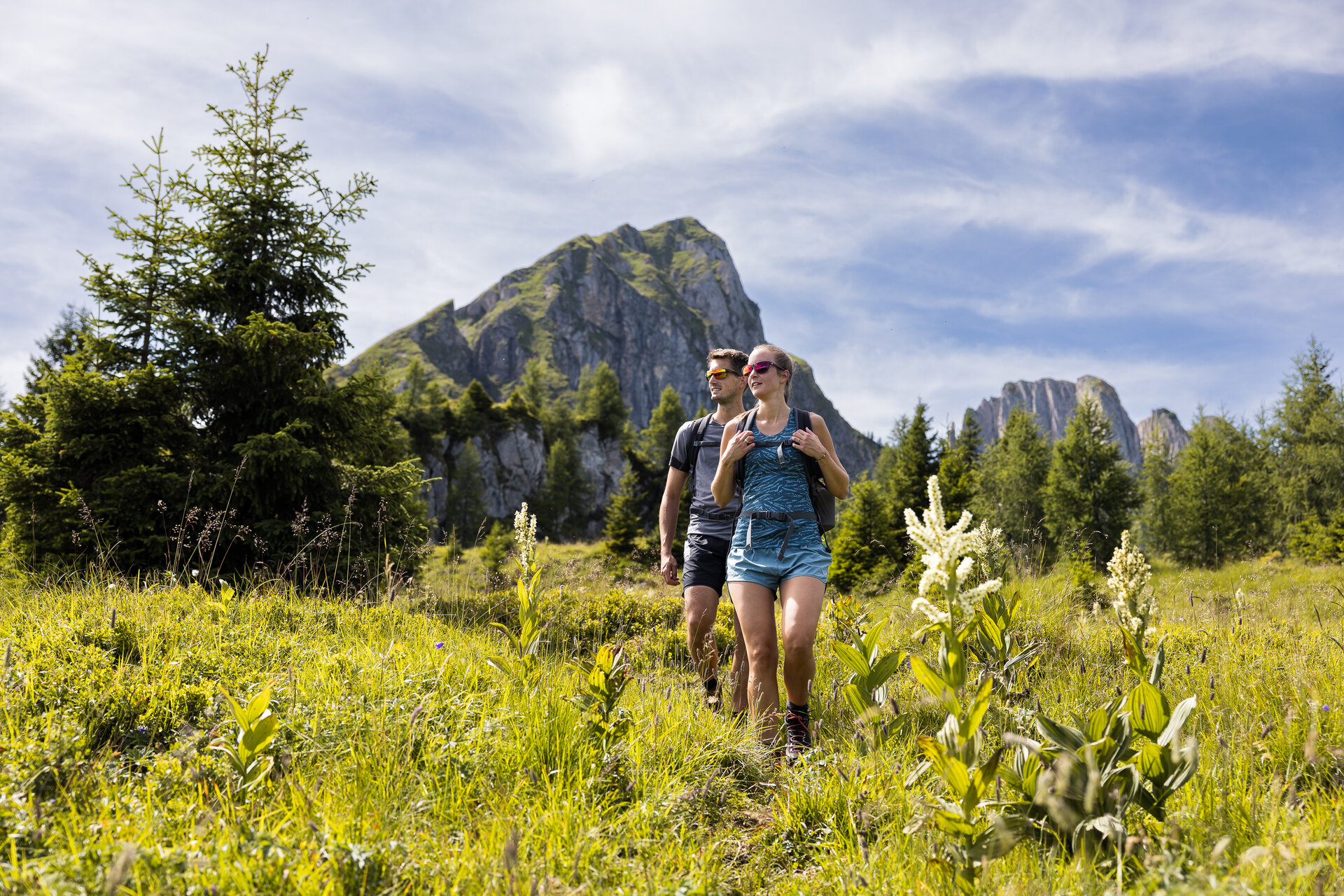 Zwei Personen wandern in den Bergen des Salzburger Landes, umgeben von schöner Natur und frischer Luft.