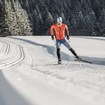 Langläufer auf der Strecke während einer Großarl Skitour, umgeben von verschneiten Bäumen und idyllischer Winterlandschaft | © © SalzburgerLand Tourismus