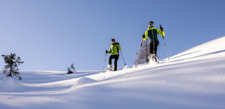 Zwei Schneeschuhwanderer genießen die verschneite Landschaft bei einer Großarl Skitour 