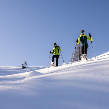 Zwei Schneeschuhwanderer genießen die verschneite Landschaft bei einer Großarl Skitour 