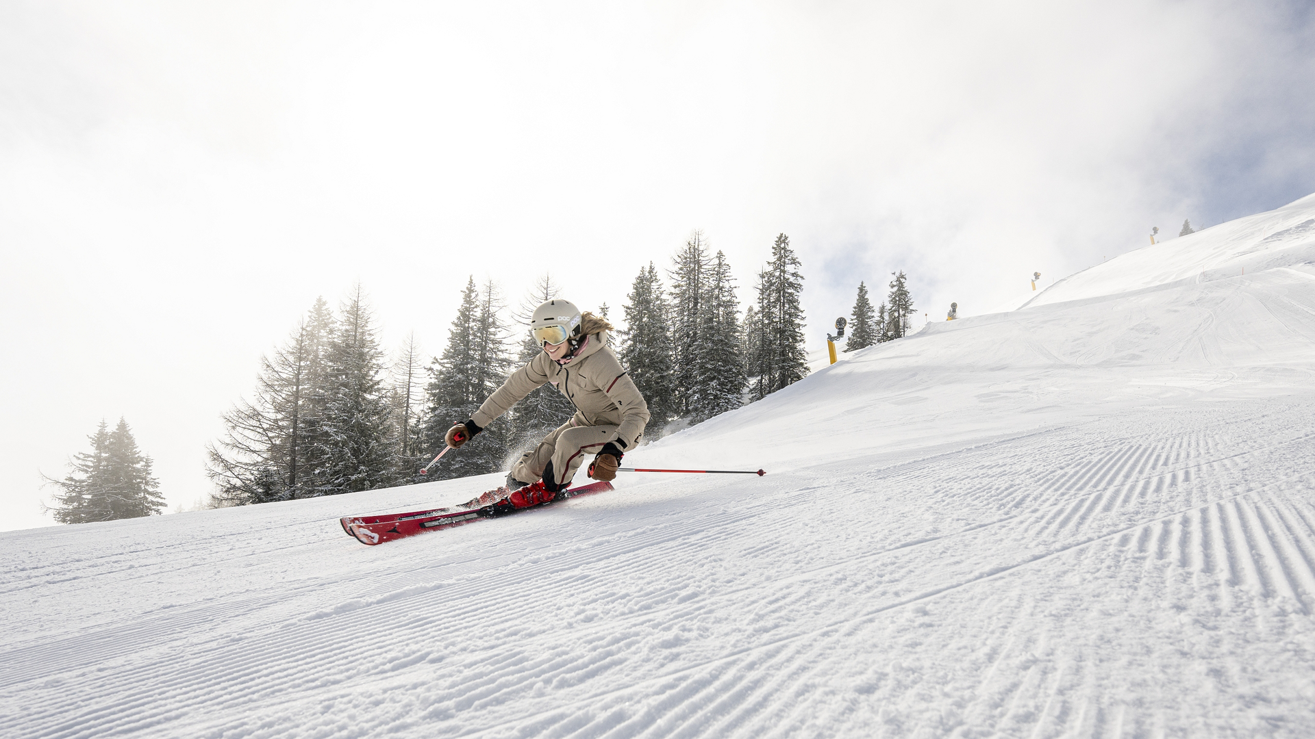 Skifahrerin bei einer schwungvollen Abfahrt auf einer frisch präparierten Skipiste im Großarltal.
