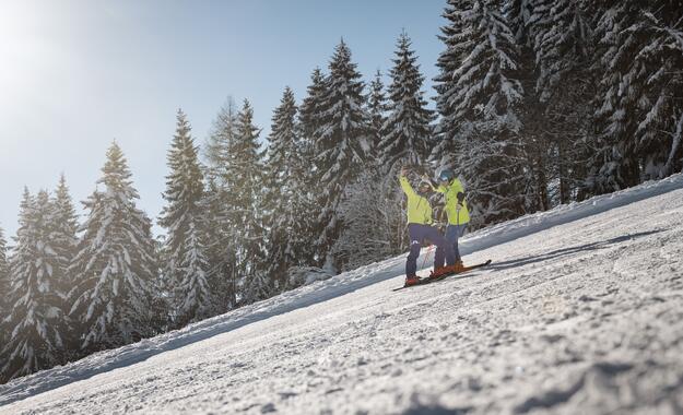 Zwei Skifahrer posieren auf der Piste in ihrem Skiurlaub im Salzburger Land | © SalzburgerLand Tourismus