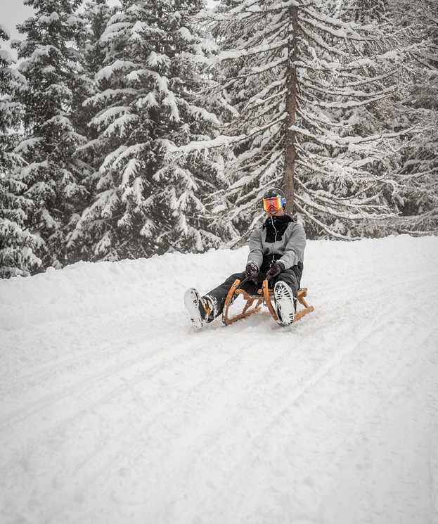 Tobogganing on a natural toboggan run through the snowy winter landscape of the Grossarl Valley